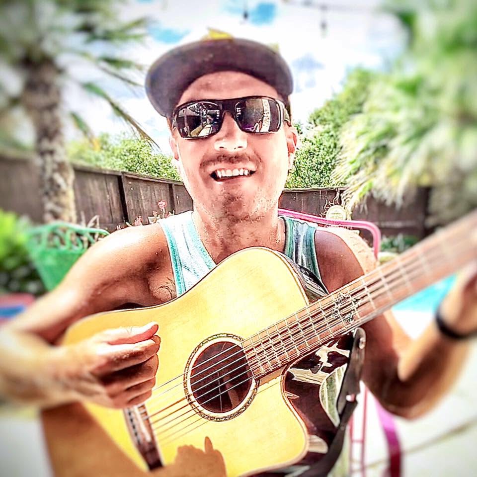 Travis Damron playing acoustic guitar